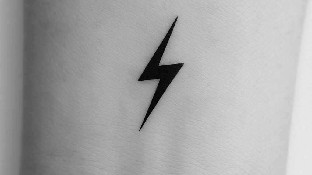 Small tattoo imspo tiny anchor shown on wrist with skiny lightly background